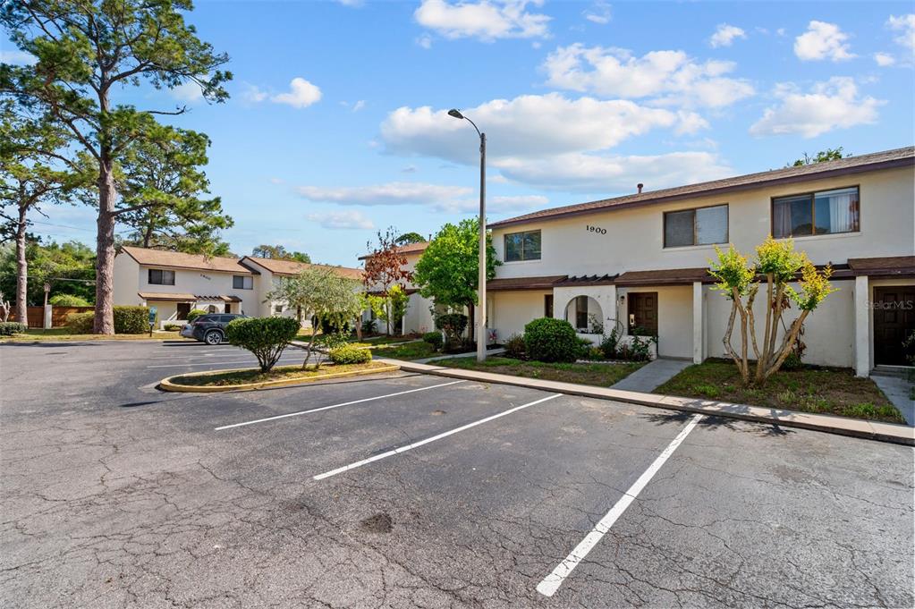 A two-story apartment building with a parking lot in the foreground under a blue sky — 2635 SW 35TH PLACE UNIT 1903, GAINESVILLE, FL