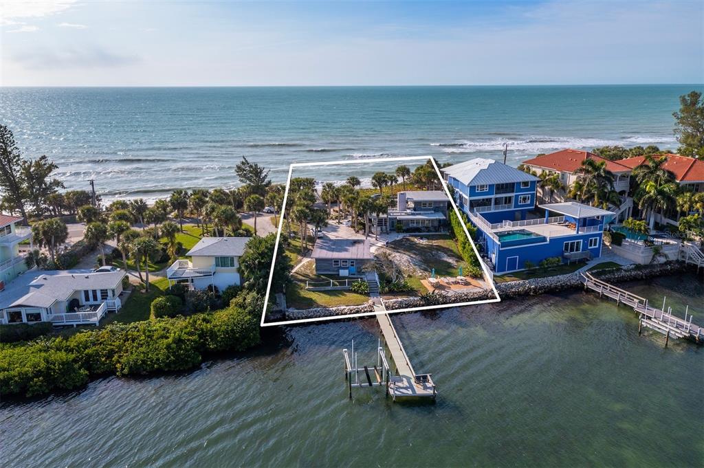 An aerial view shows a waterfront property with a dock, two houses, and palm trees — 1620 CASEY KEY ROAD, NOKOMIS, FL