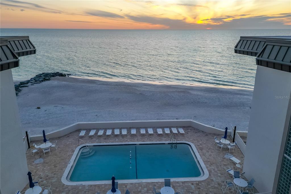 An elevated view of a swimming pool on a patio overlooking a sandy beach — 1900 BENJAMIN FRANKLIN DRIVE UNIT V12, SARASOTA, FL