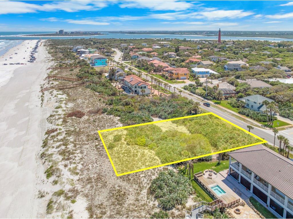 An aerial view shows a vacant, rectangular oceanfront lot outlined in yellow near a beach — 4861 S ATLANTIC AVENUE, PONCE INLET, FL