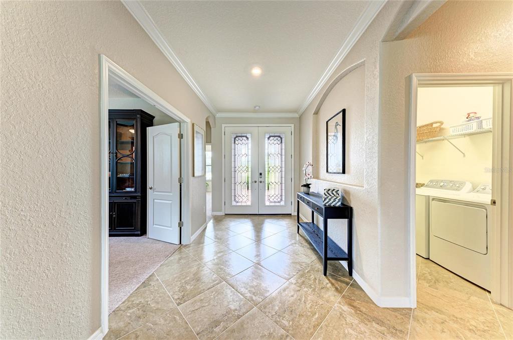 A tiled entryway features a console table, double front doors, and an adjacent laundry room — 538 FIRE BUSH COURT, BRADENTON, FL