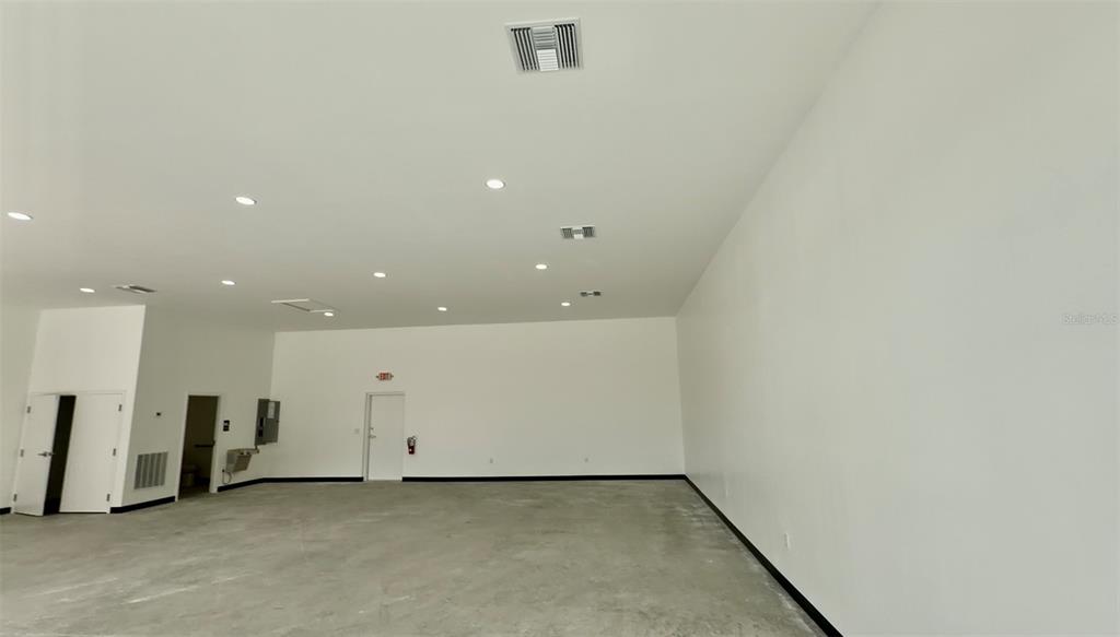 An empty, unfinished room with white walls, recessed lighting, and a concrete floor — 727 TILLMAN PLACE UNIT 102, PLANT CITY, FL