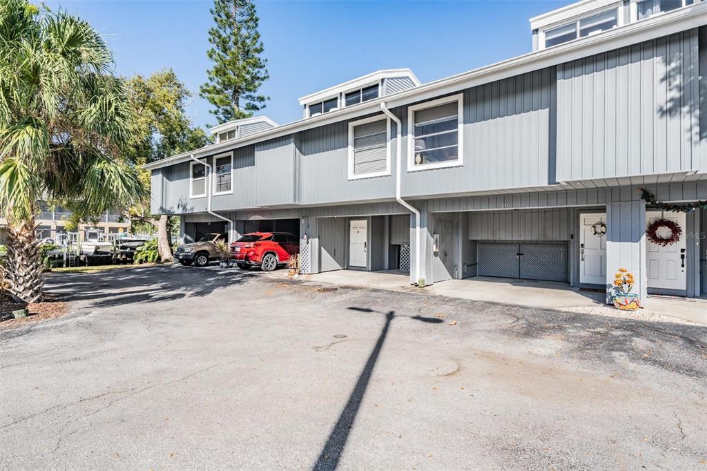 A multi-story gray townhouse building with covered parking and a paved driveway — 200 MERES BOULEVARD UNIT 16, TARPON SPRINGS, FL