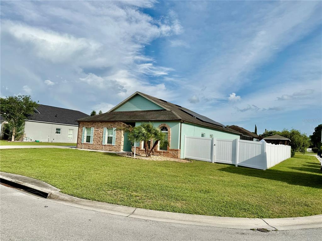A light green house with a brick facade and a white vinyl fence — 1201 LAVENDER JEWEL COURT, PLANT CITY, FL