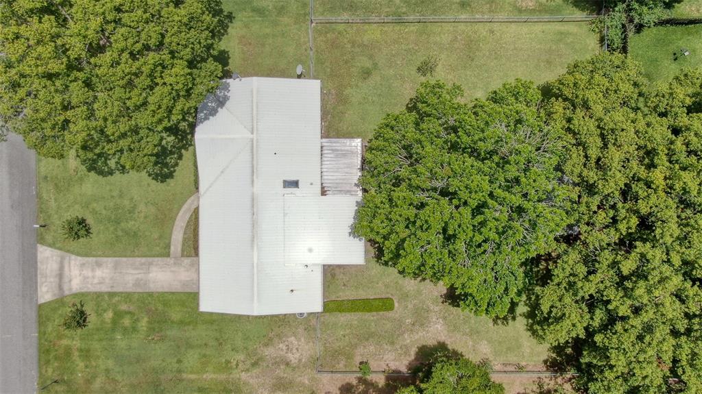 An aerial view shows a house with a metal roof, a driveway, and large trees — 4816 NE 6TH STREET, OCALA, FL
