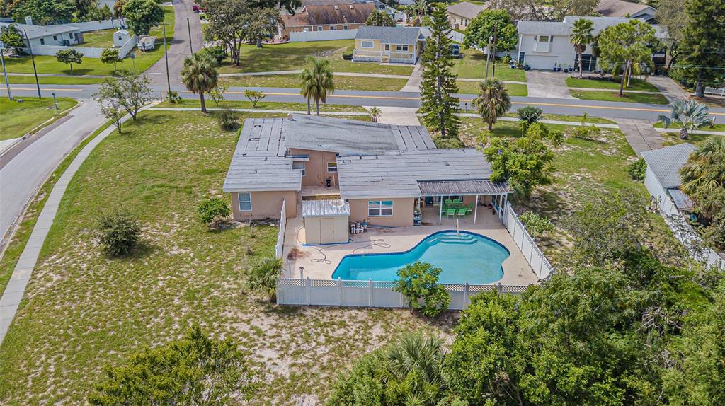An aerial view shows a single-story house with a swimming pool and fenced backyard — 912 RIVERSIDE DRIVE, TARPON SPRINGS, FL