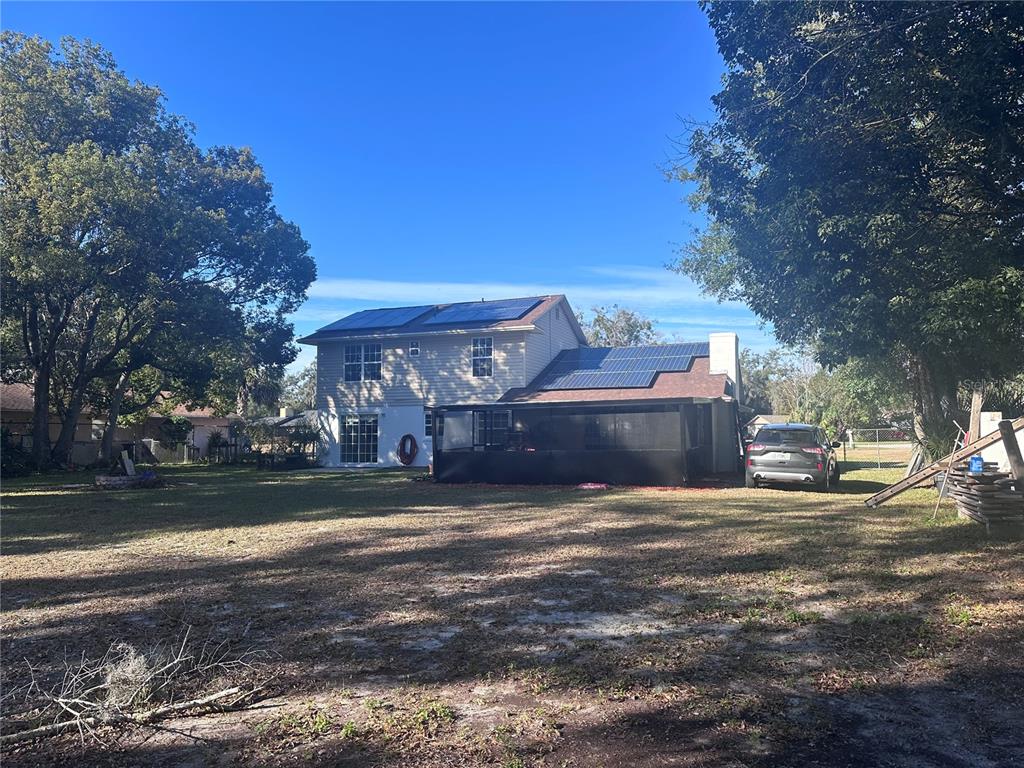 A two-story house with solar panels on the roof and a screened-in back porch — 5710 JACQULYN DRIVE, ZELLWOOD, FL