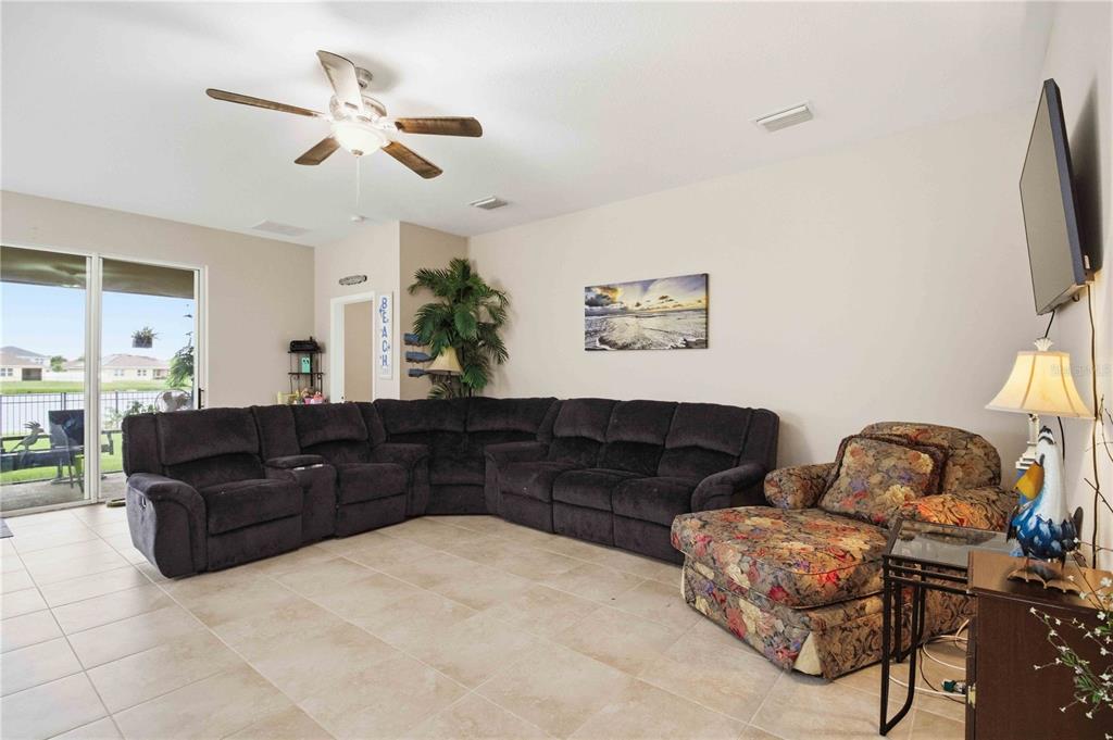 A living room features a large dark sectional, a floral armchair, and sliding glass doors — 444 TIERRA VERDE WAY, BRADENTON, FL