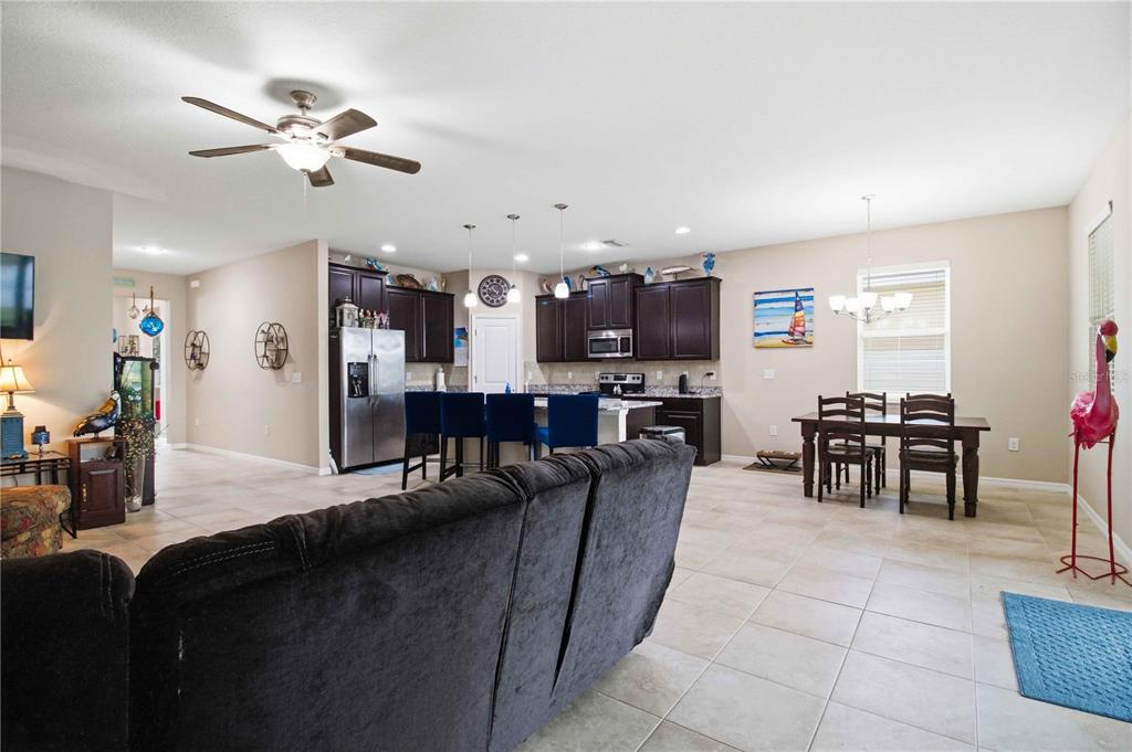 An open-concept living area features a kitchen with dark cabinetry, a dining table, and tile flooring — 444 TIERRA VERDE WAY, BRADENTON, FL
