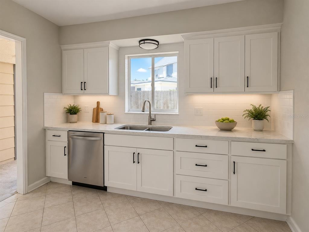 A kitchen with white cabinets, a stainless steel dishwasher, and a window above the sink — 401 PATICA ROAD NE, ST PETERSBURG, FL