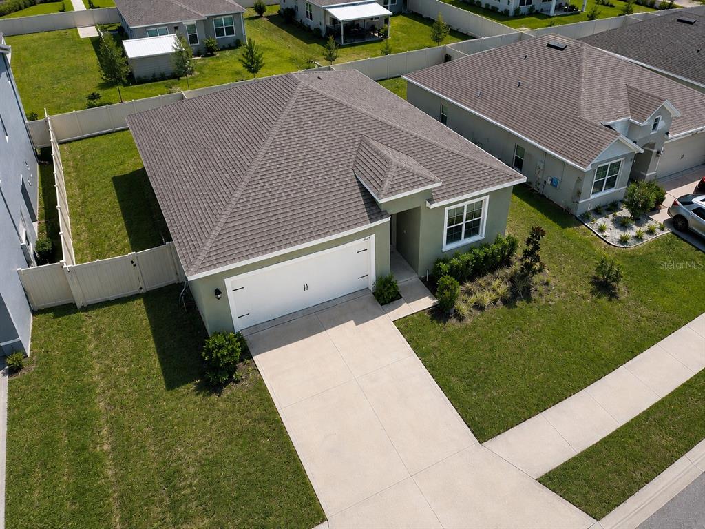 An aerial view of a single-story suburban house with a two-car garage and fenced yard — 4669 BERNARD BOULEVARD, HAINES CITY, FL