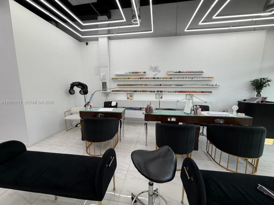 A modern nail salon features two manicure stations, wall-mounted polish displays, and black velvet chairs — 8290 SW 40th St, Miami FL 33155, MIAMI, FL