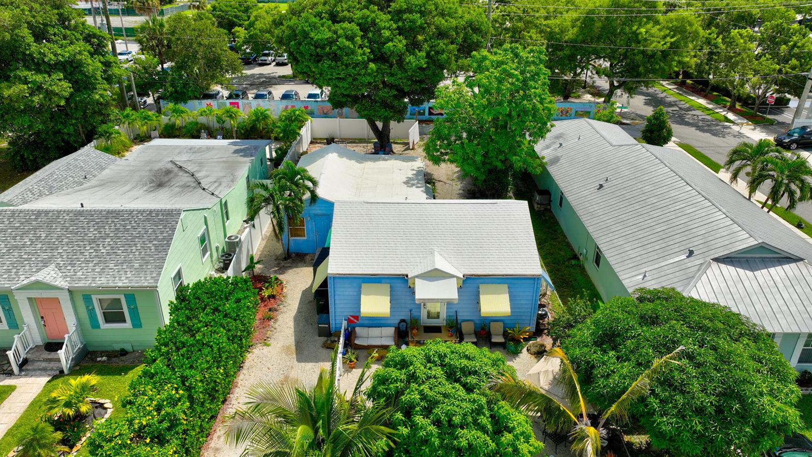 An aerial view shows three small houses with light-colored roofs and blue or green siding — 629 SE 4th Avenue, Delray Beach FL 33483, DELRAY BEACH, FL