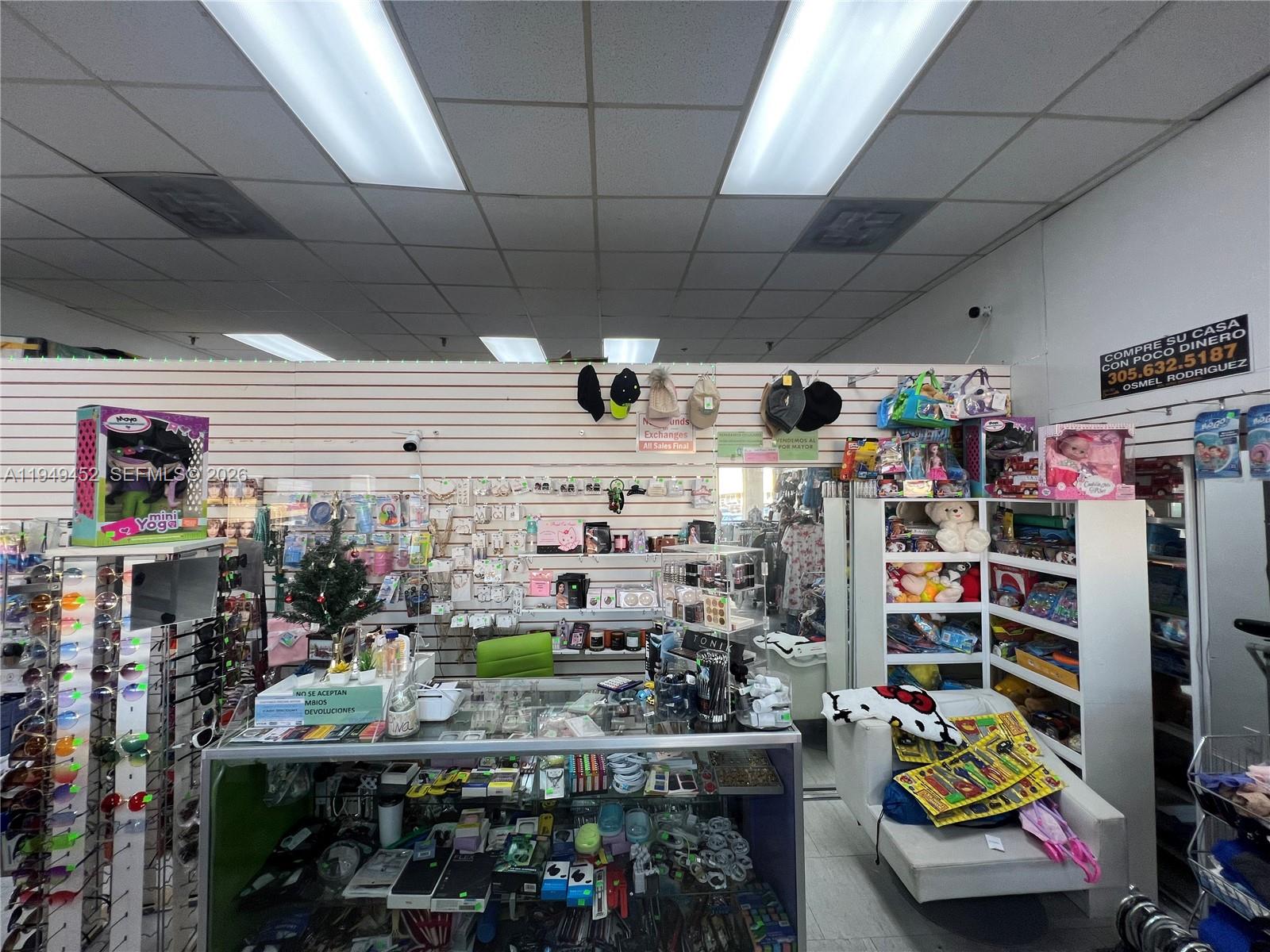 A retail store interior features display cases, wall-mounted merchandise, and shelves filled with various products — 500 W 49th St, Hialeah FL 33012, HIALEAH, FL