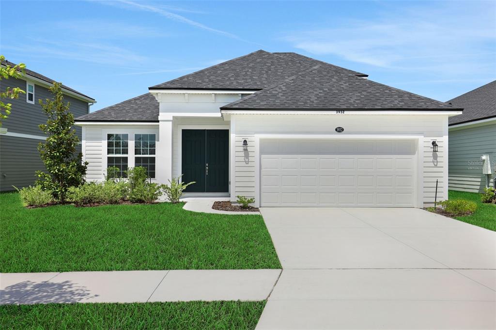 A single-story house with white siding, a dark roof, and a two-car garage — 3932 HOLSTEIN WAY, GREEN COVE SPRINGS, FL