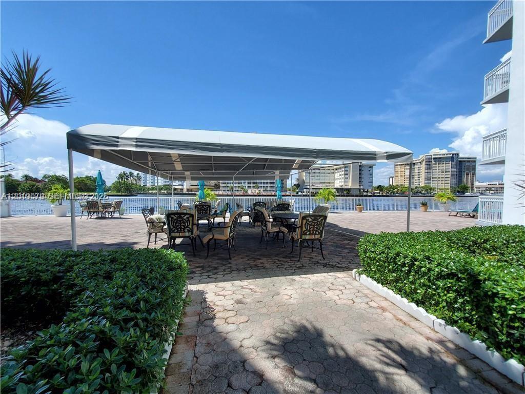 A patio area features a large canopy, outdoor furniture, and a view of the water — 1913 S Ocean Dr # 212, Hallandale Beach FL 33009, HALLANDALE BEACH, FL