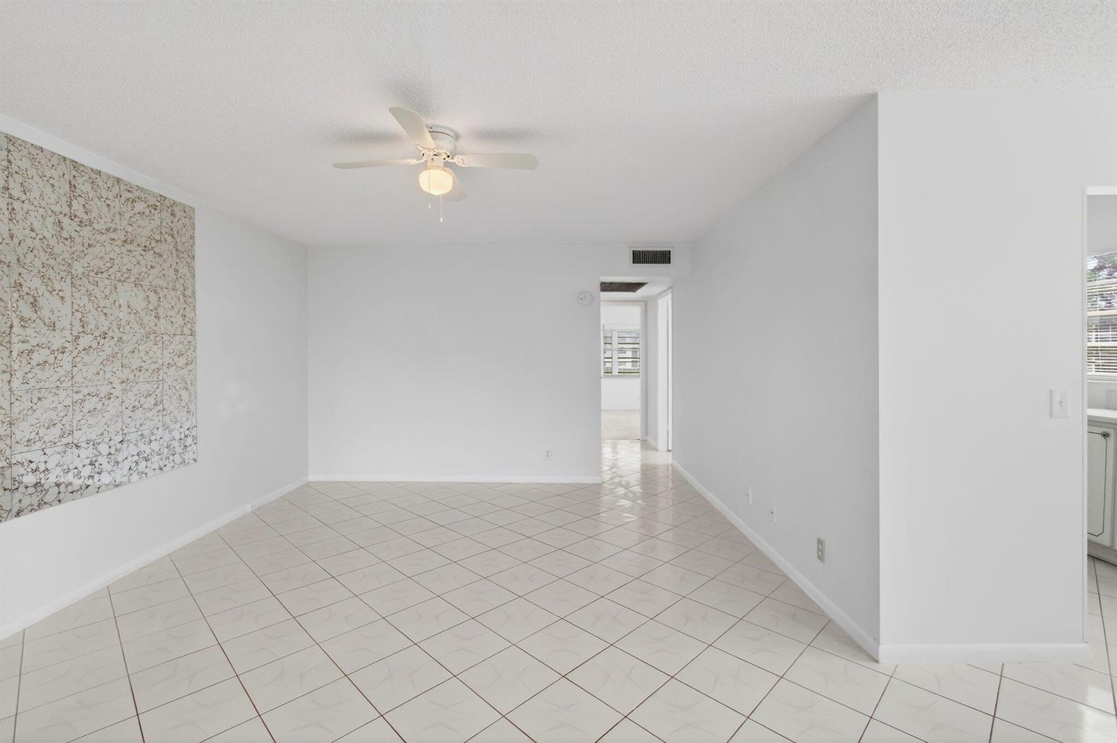 An empty room with white walls, a ceiling fan, and light-colored diagonal floor tiles — 360 Fanshaw I, Boca Raton FL 33434, BOCA RATON, FL