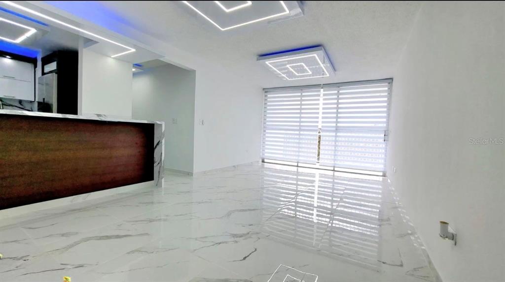 A modern living room features white marble floors, recessed ceiling lighting, and a kitchen island — APT 6 A CARR 833 UNIT 6a, GUAYNABO, PR