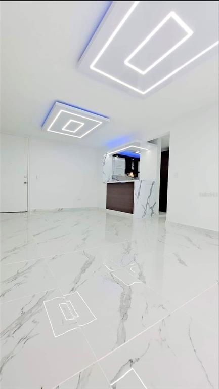 A modern room features white marble-look tile flooring and recessed ceiling lights with blue accents — APT 6 A CARR 833 UNIT 6a, GUAYNABO, PR