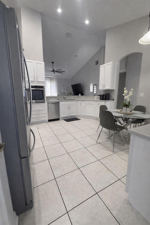 A kitchen with white cabinets, stainless steel appliances, and a dining area with a table — 2240 BAGDAD AVENUE, ORLANDO, FL