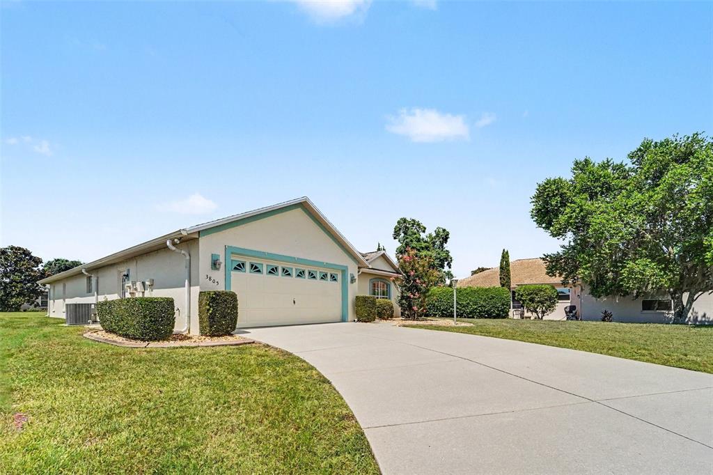 A living room with a sectional sofa, coffee table, and open kitchen with wood cabinets — 3805 E KIWI COVE CT, HERNANDO, FL