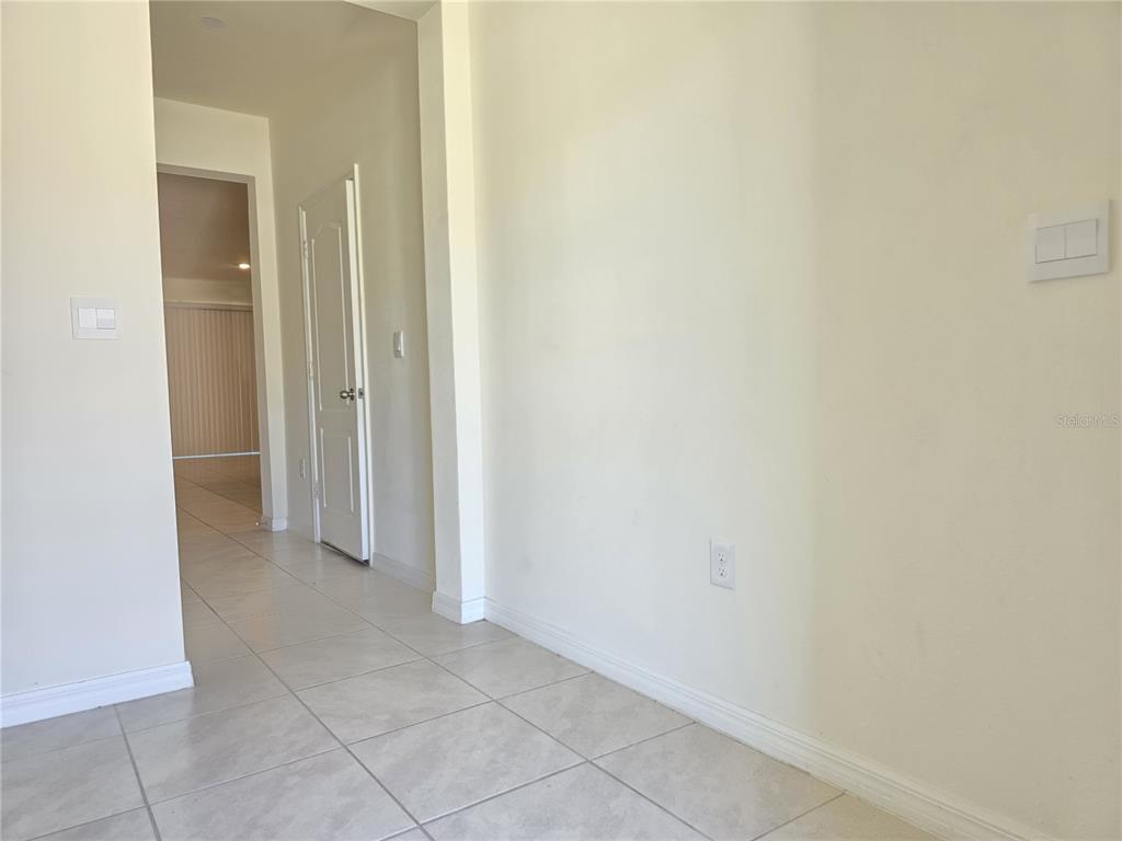 An interior view shows a tiled hallway leading to a room with light-colored walls — 1242 LIDO DRIVE, HOWEY IN THE HILLS, FL
