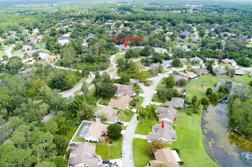 An aerial view shows a suburban neighborhood with houses, a pond, and a clubhouse — 18 CARRIAGE CREEK WAY, ORMOND BEACH, FL