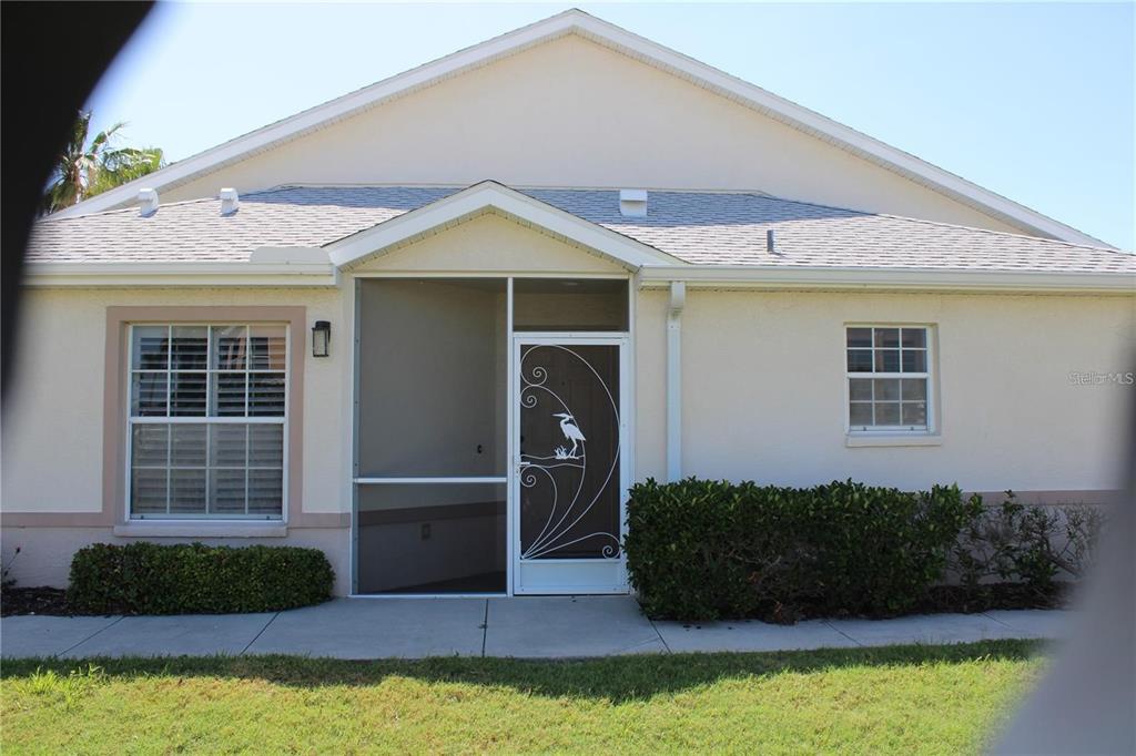 A single-story house exterior features a screened front entryway with a decorative heron design — 1702 FAIRWAY TRACE UNIT 1702, PALMETTO, FL