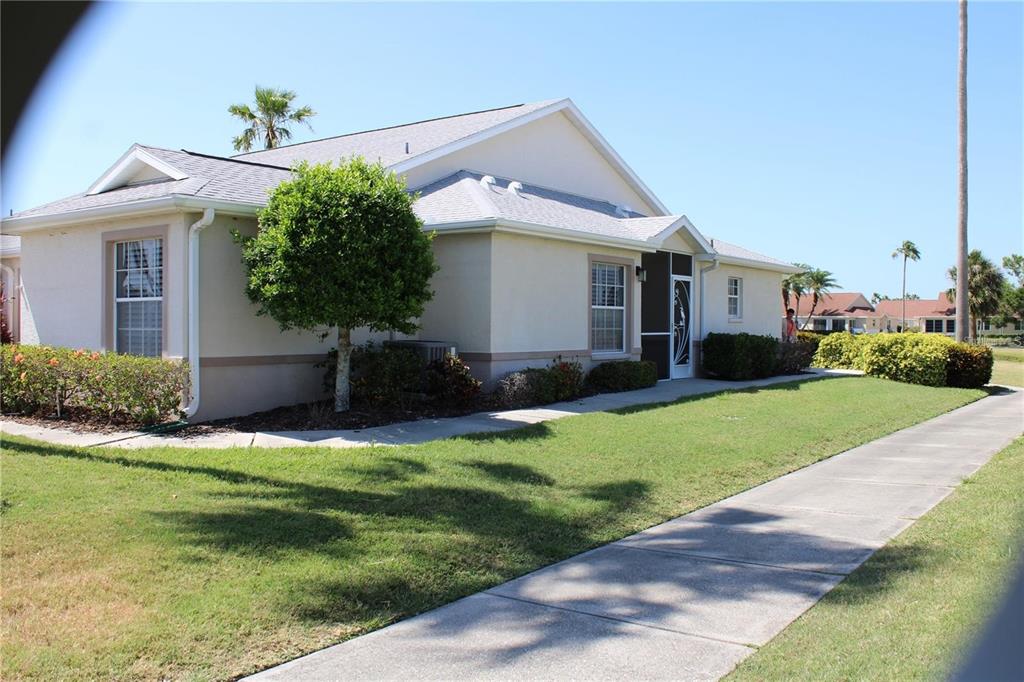 A single-story beige house with a gray shingled roof and a concrete walkway — 1702 FAIRWAY TRACE UNIT 1702, PALMETTO, FL