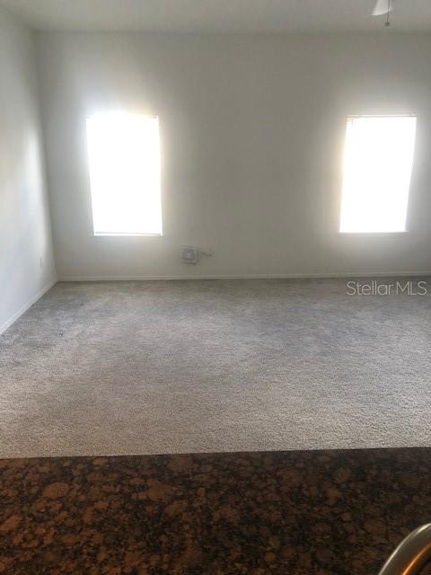 A carpeted room features two windows on a plain wall above a dark countertop — 413 SUMMIT RIDGE PLACE UNIT 305, LONGWOOD, FL