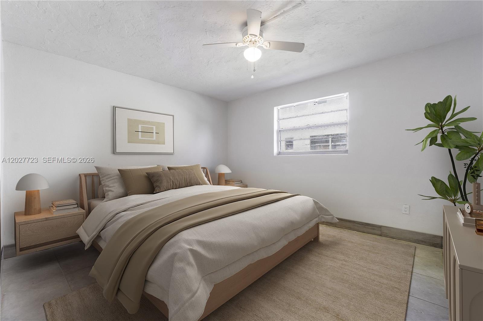 A bedroom features a bed with neutral bedding, a ceiling fan, and a window — 332 SW 3rd St # 5, Belle Glade FL 33430, BELLE GLADE, FL