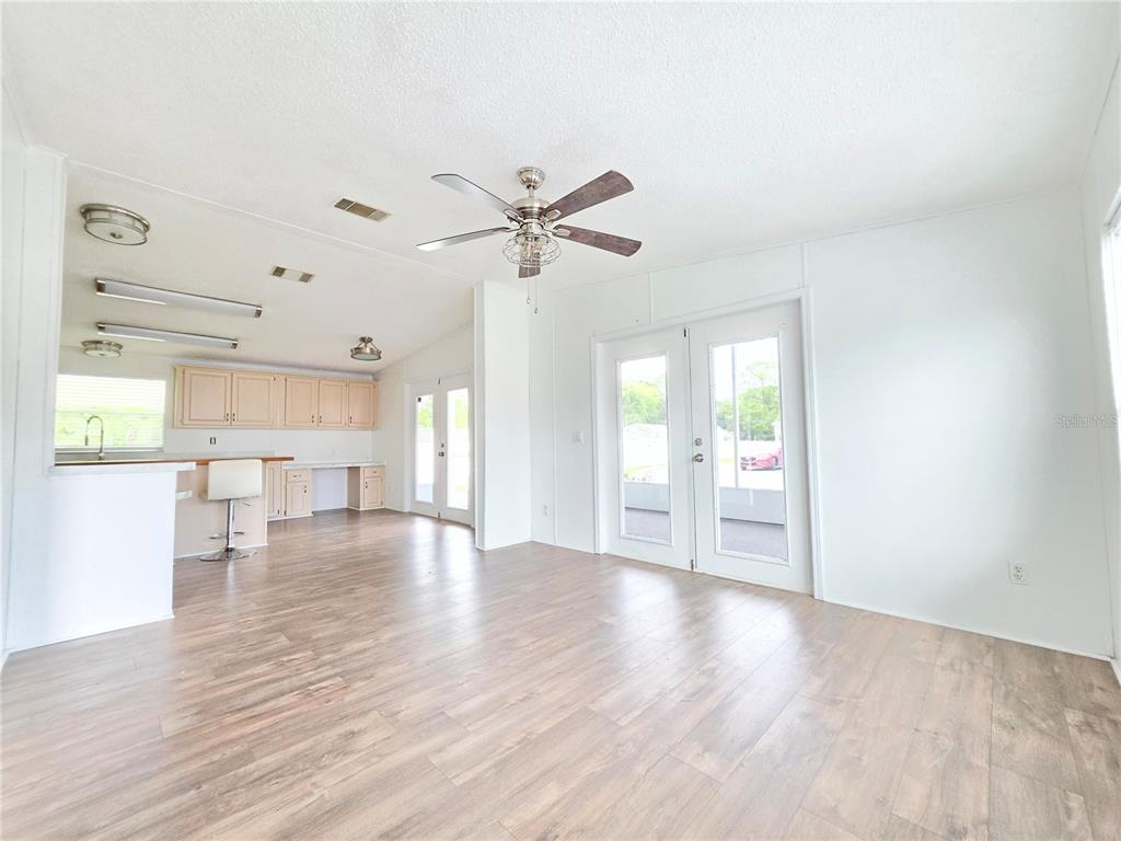A living room with a sofa, two armchairs, and a coffee table faces an open kitchen — 1000 WALKER STREET UNIT 396, HOLLY HILL, FL