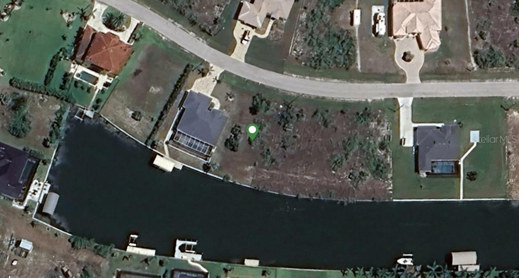 This aerial satellite map shows a vacant waterfront lot situated between two existing residential homes — 15340 ACORN CIRCLE, PORT CHARLOTTE, FL