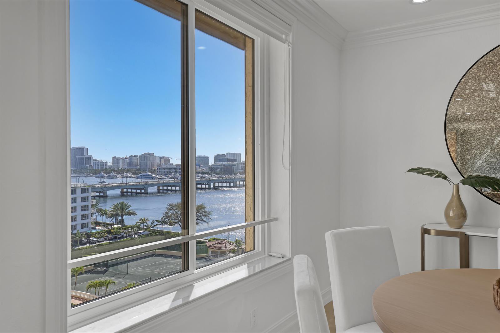 A dining area features a large window overlooking a bridge, water, and city skyline — 150 Bradley Place # 605, Palm Beach FL 33480, PALM BEACH, FL