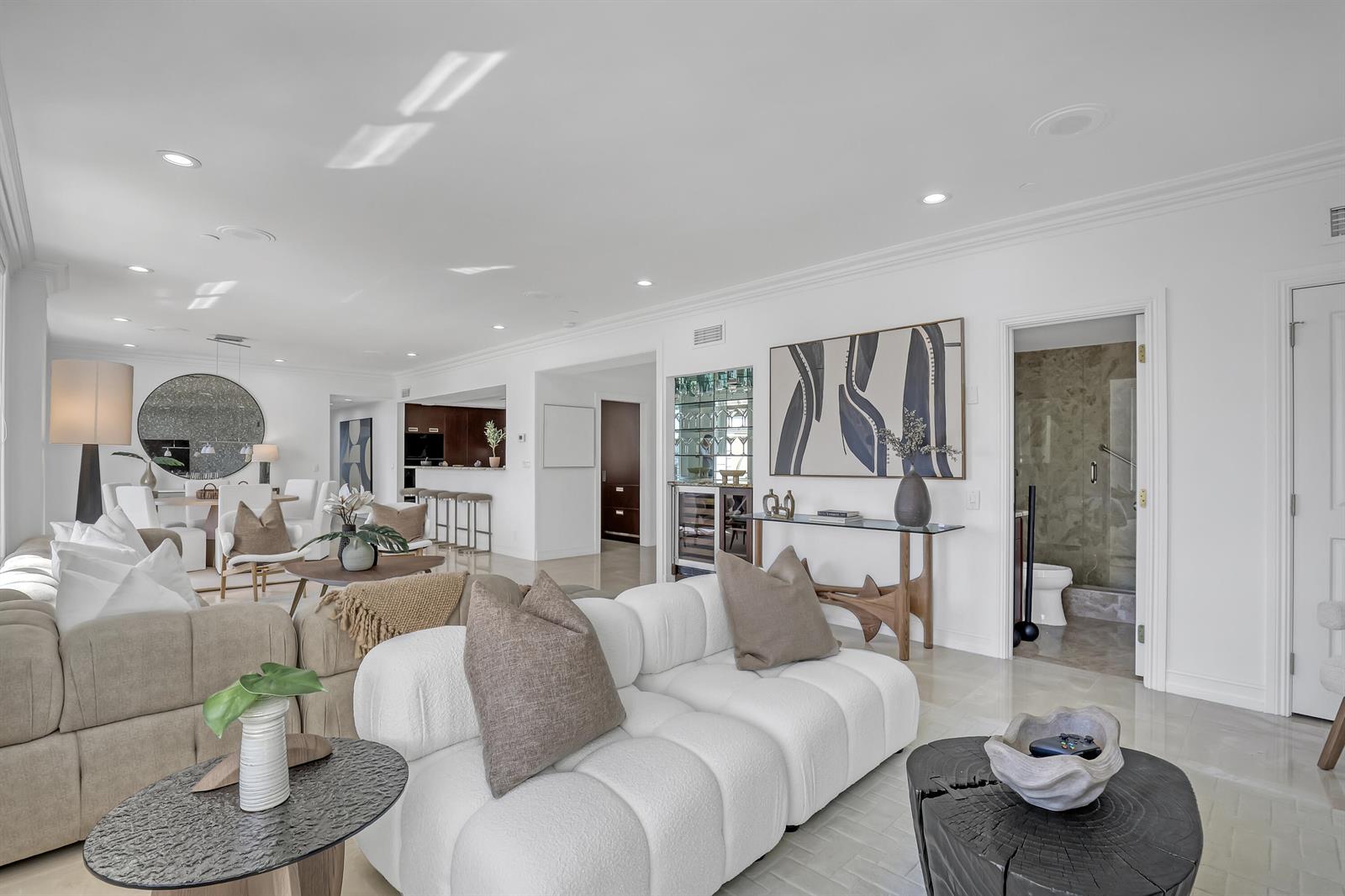 A bright, open-concept living room features white sofas, a bar area, and a tiled floor — 150 Bradley Place # 605, Palm Beach FL 33480, PALM BEACH, FL