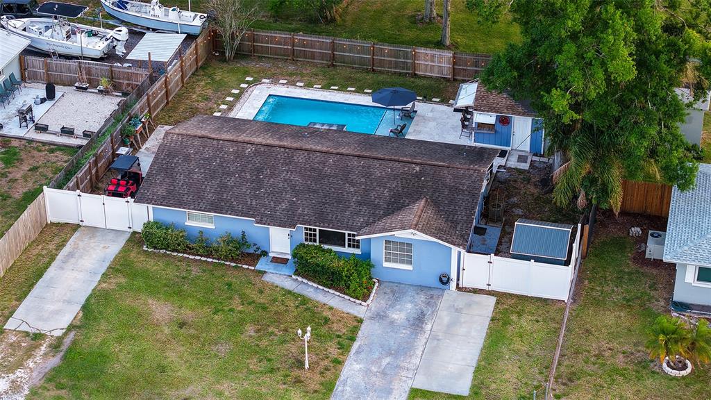 An aerial view shows a blue house with a pool, patio, and detached storage shed — 311 44TH STREET COURT W, PALMETTO, FL