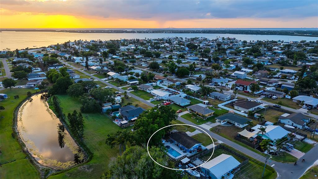 An aerial view shows a residential neighborhood with a circled house featuring a backyard pool — 311 44TH STREET COURT W, PALMETTO, FL