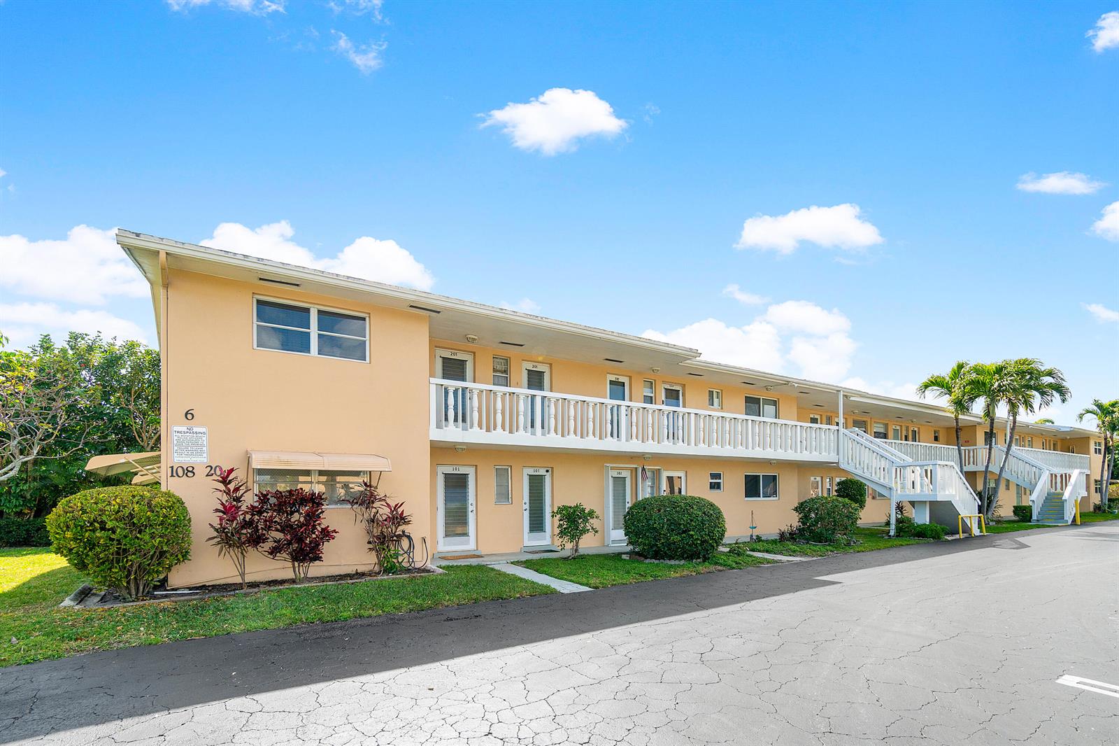 A two-story peach-colored apartment building with a white balcony and exterior staircase — 108 NE 20th Avenue NE # 201, Boynton Beach FL 33435, BOYNTON BEACH, FL