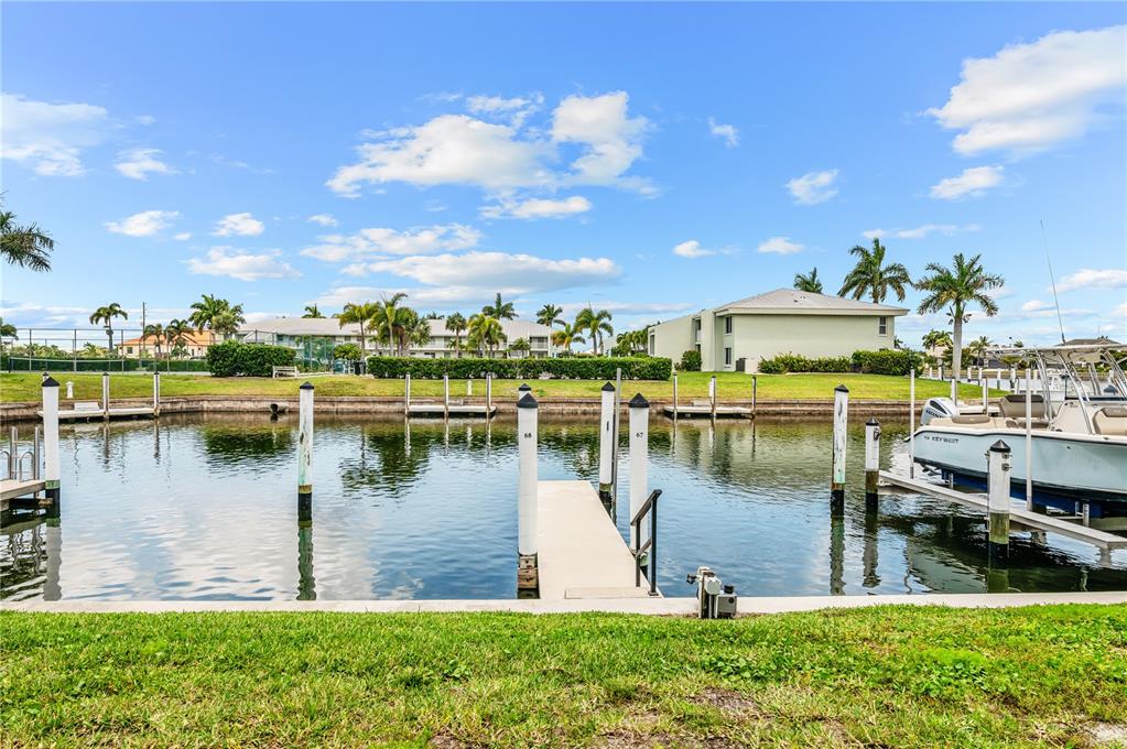 A canal view shows boat slips with wooden docks and pilings in front of apartments — 3640 BAL HARBOR BOULEVARD UNIT 112, PUNTA GORDA, FL