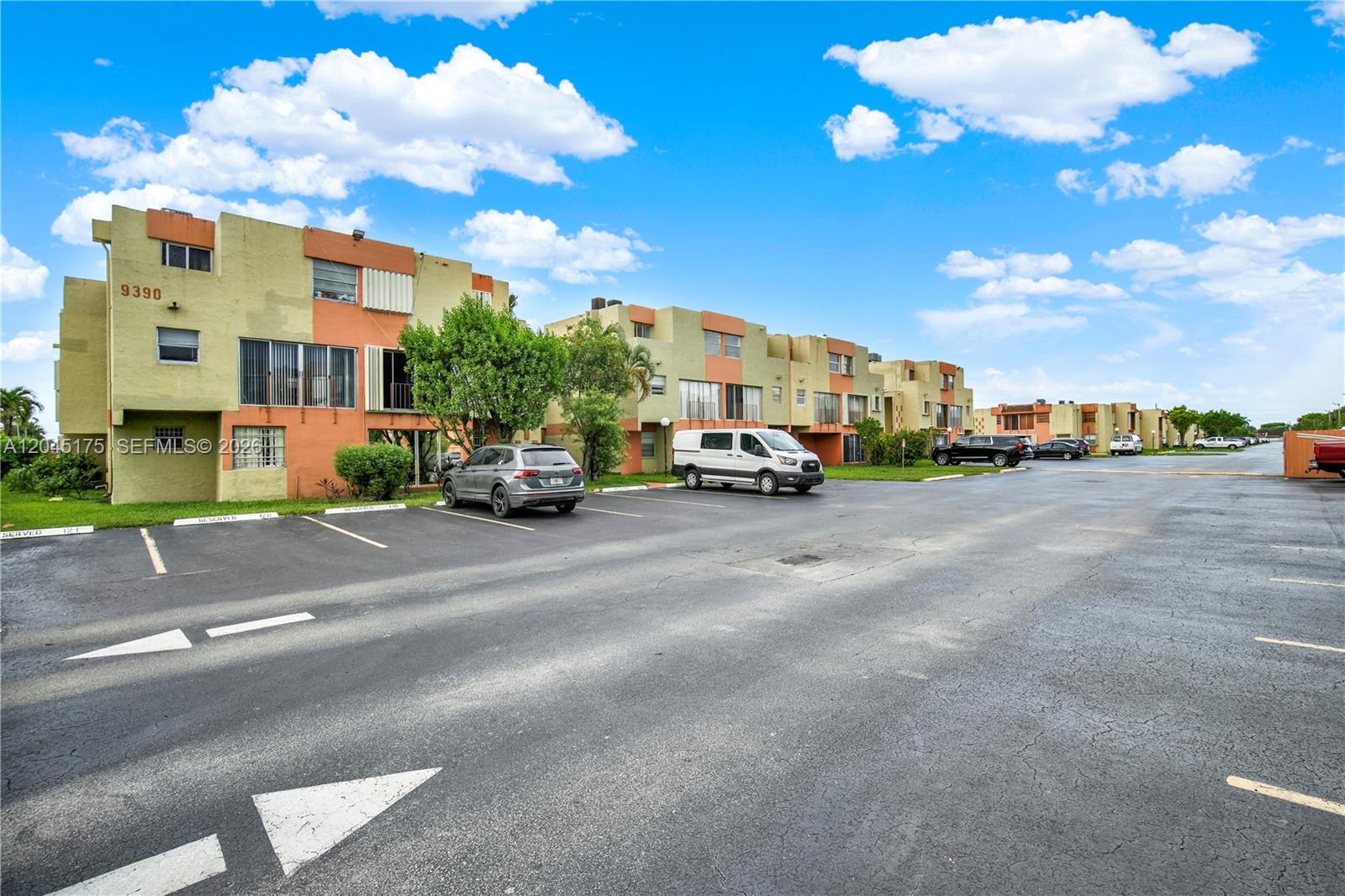 A multi-story apartment complex features tan and orange stucco walls with a paved parking lot — 9390 W Flagler St # 218F, Miami FL 33174, MIAMI, FL