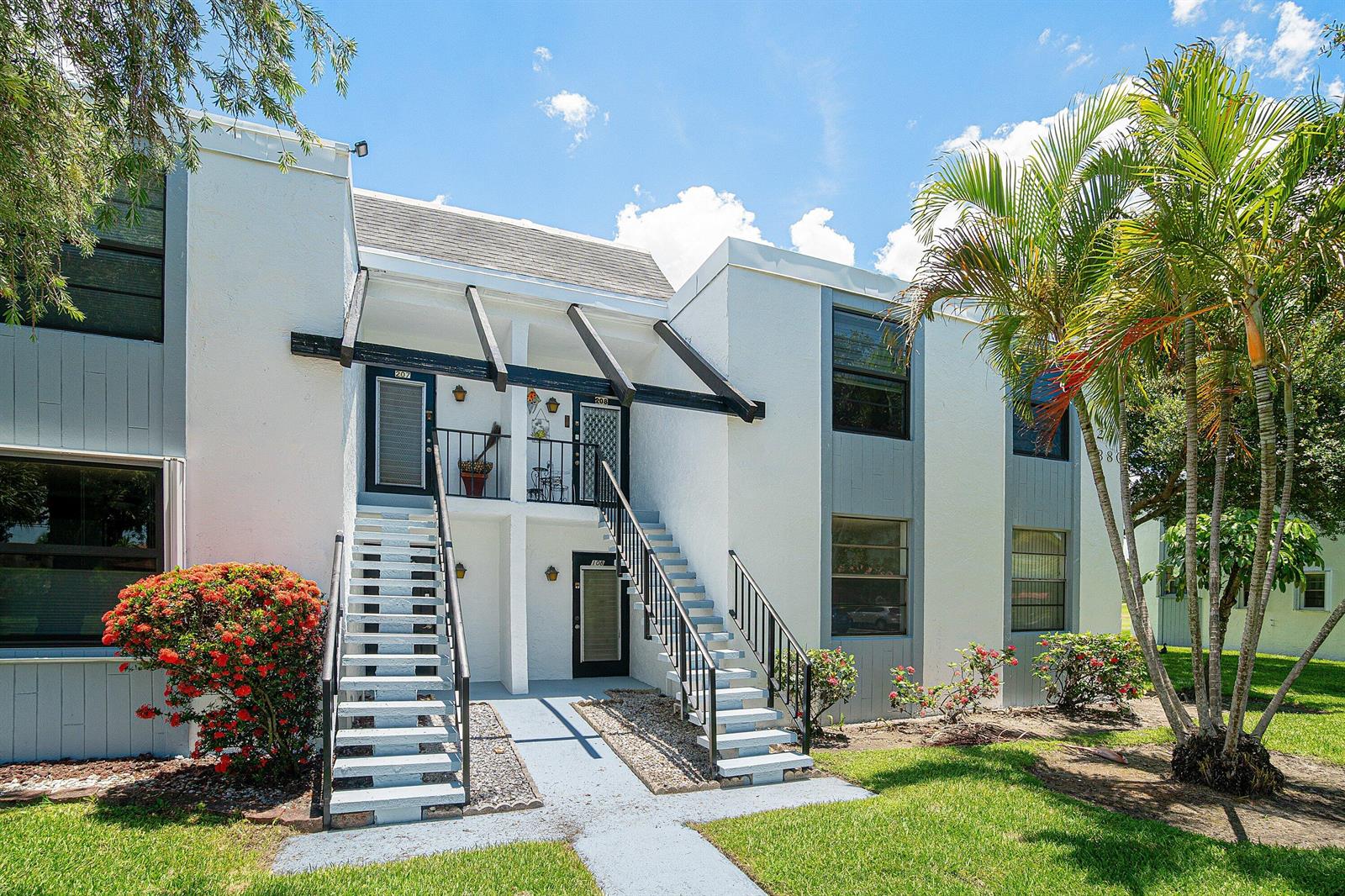 A two-story apartment building with white stucco walls, black railings, and exterior staircases — 7380 NW 18th Street # 108, Margate FL 33063, MARGATE, FL