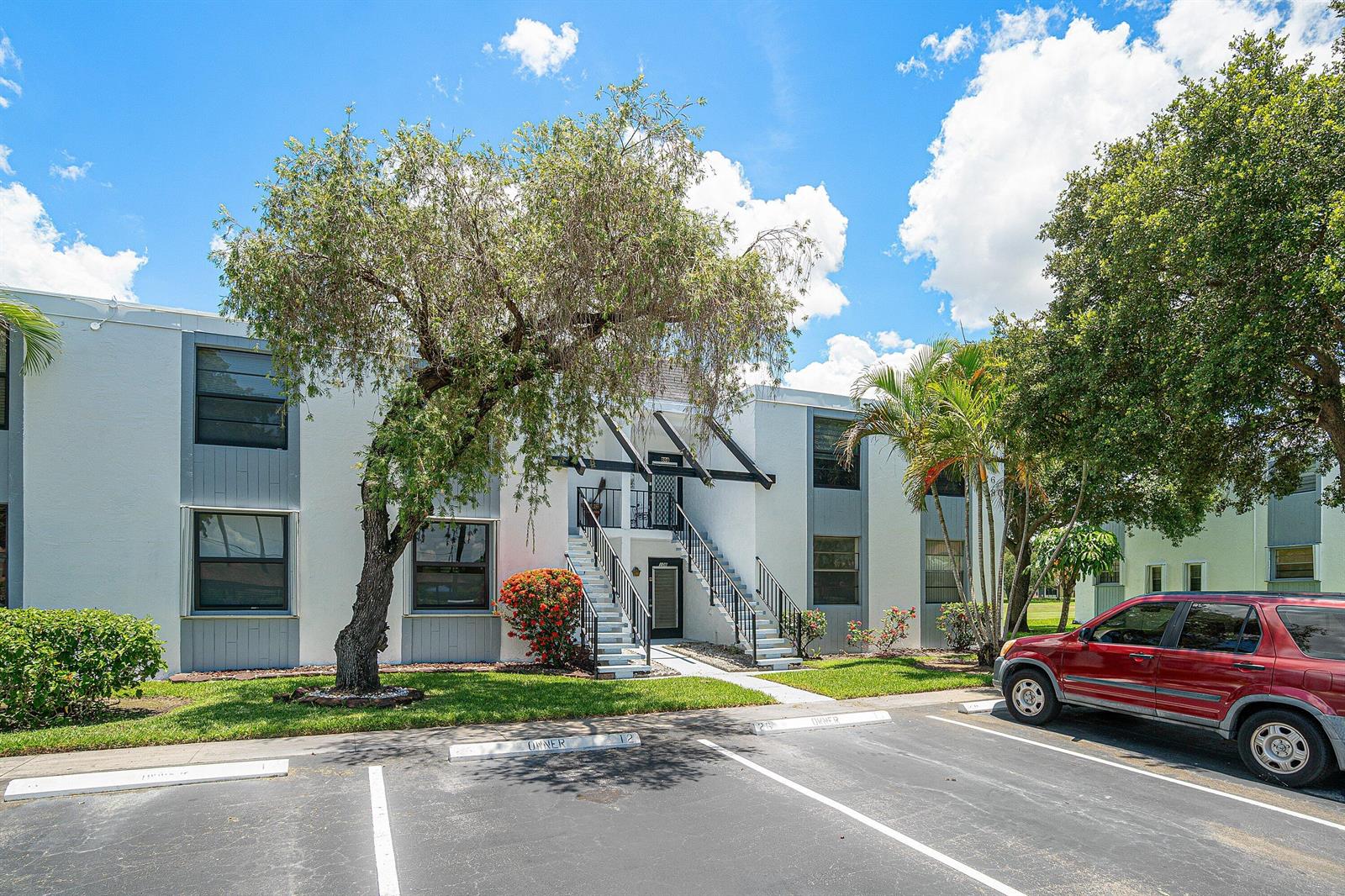A two-story apartment building with a red SUV parked in the foreground — 7380 NW 18th Street # 108, Margate FL 33063, MARGATE, FL
