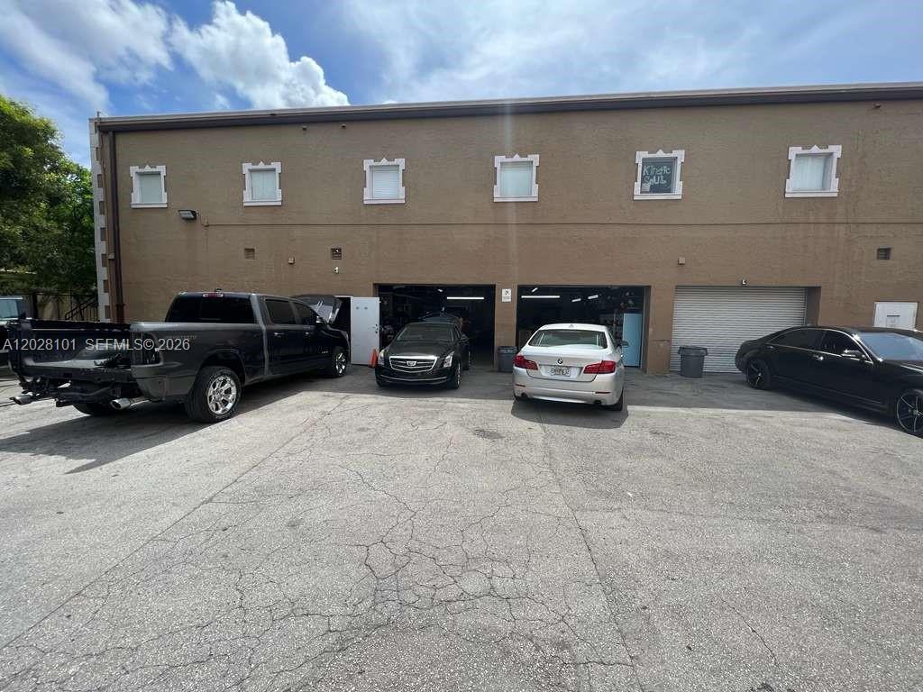 A two-story commercial building features multiple garage bays and several parked vehicles in front — 13690 SW 142nd Ave, Miami FL 33186, MIAMI, FL