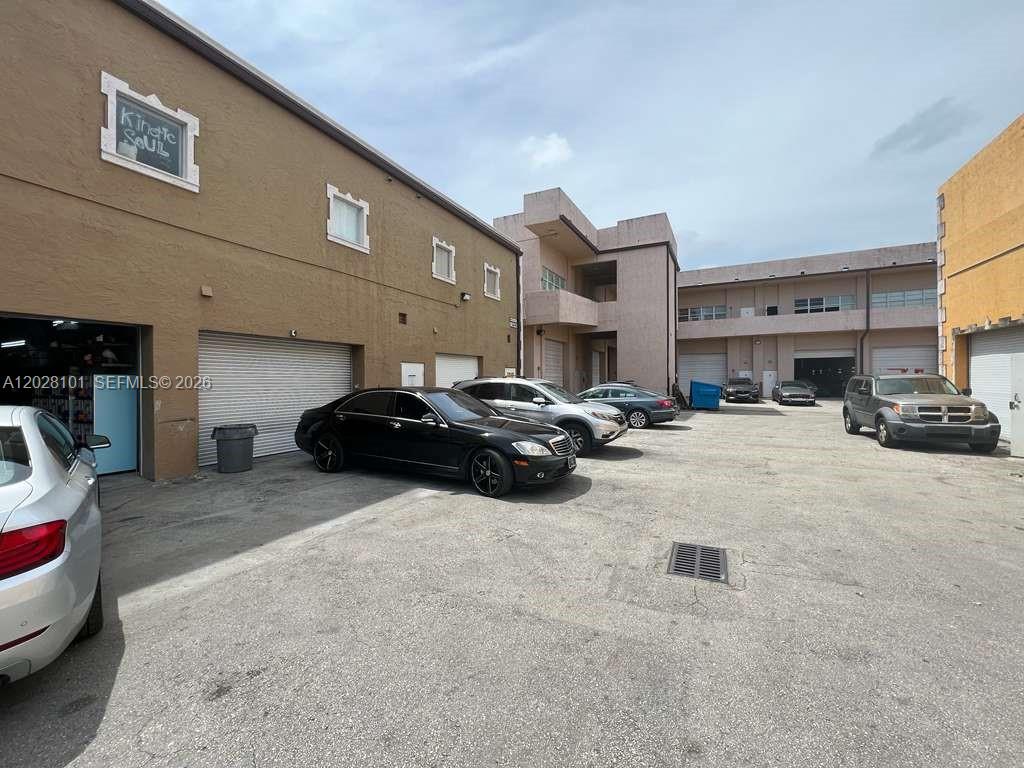 An exterior view of a commercial building with a parking lot and several parked cars — 13690 SW 142nd Ave, Miami FL 33186, MIAMI, FL