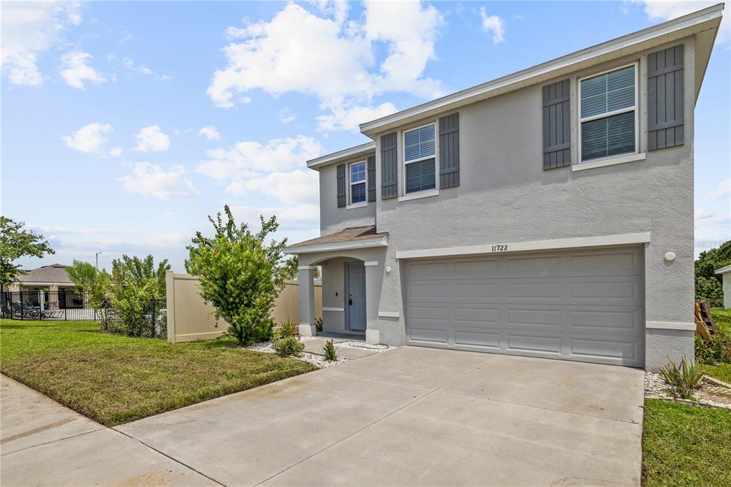 A two-story house with a gray stucco exterior, a two-car garage, and a concrete driveway — 11722 WHITE WILLOW LANE, RIVERVIEW, FL