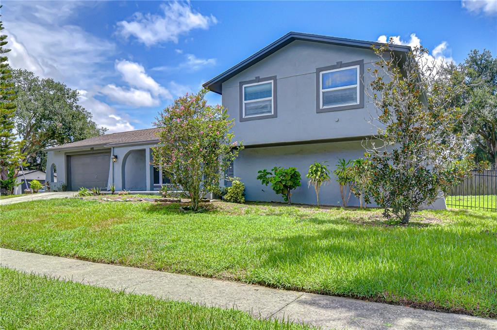 A two-story gray house with a garage and a front lawn under a blue sky — 4723 SOUTHBREEZE DRIVE, TAMPA, FL