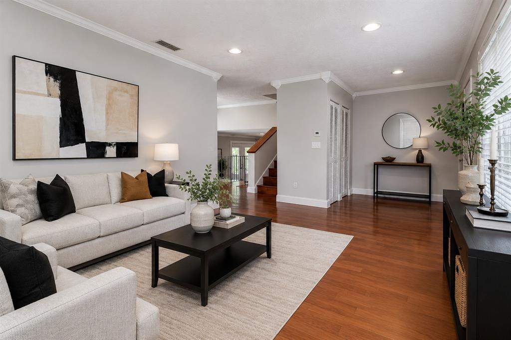 A living room features light gray walls, hardwood floors, a neutral sofa, and black furniture — 4723 SOUTHBREEZE DRIVE, TAMPA, FL