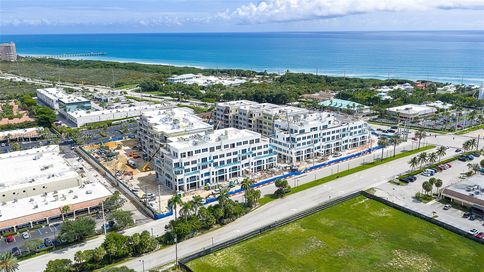 An aerial view shows a large, multi-story white building under construction near the ocean — 1011 US Highway One # B405, Juno Beach FL 33408, JUNO BEACH, FL