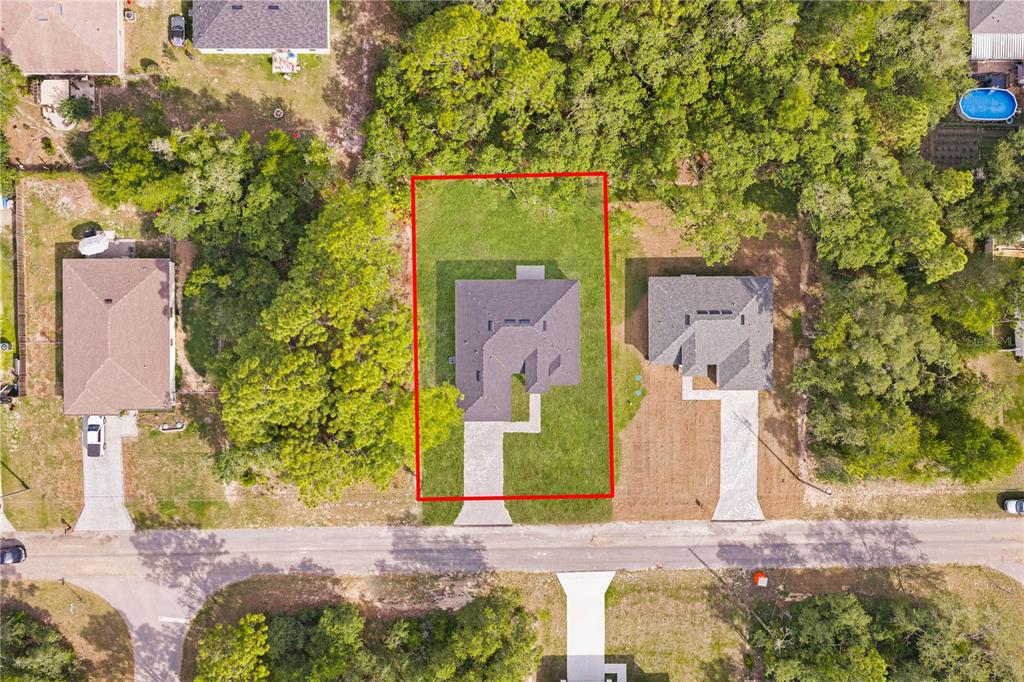 An aerial view shows a single-family home centered on a rectangular lot with a driveway — 8555 N TROJAN DRIVE, CITRUS SPRINGS, FL