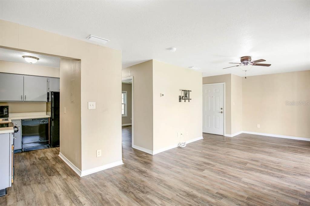 An open-concept living area features wood-look flooring and a kitchen with grey cabinets — 4995 COBIA DRIVE SE UNIT D, ST PETERSBURG, FL